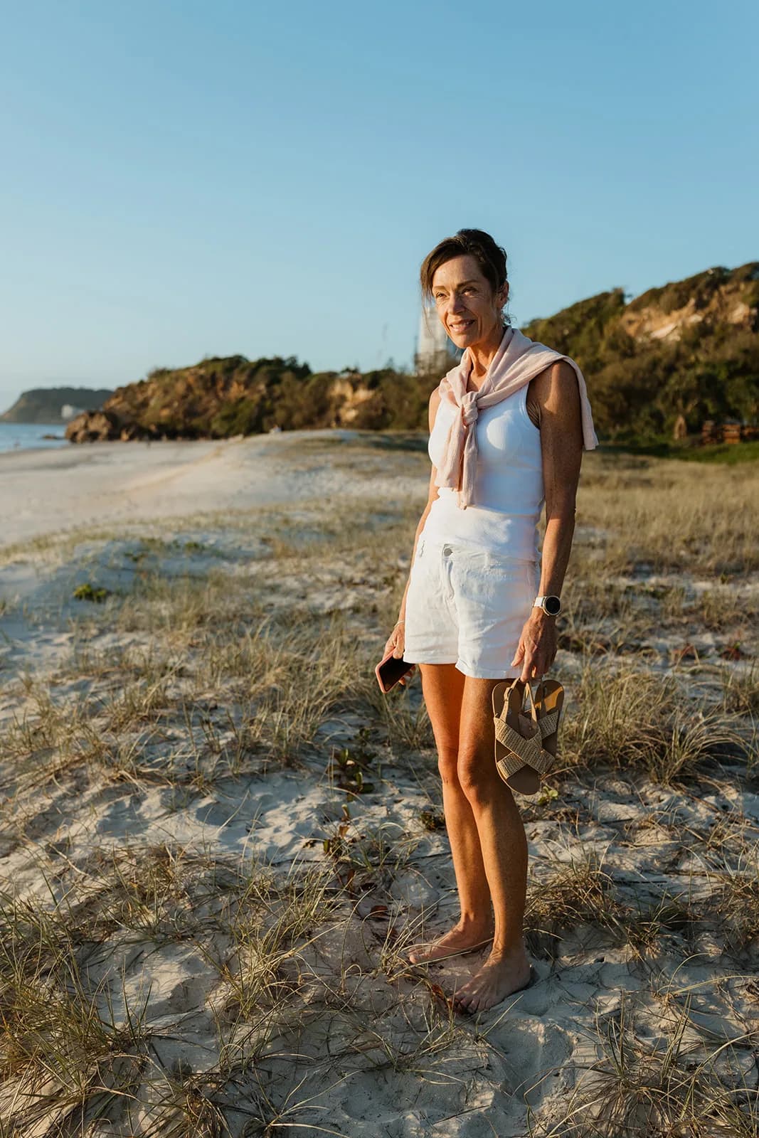 Dana Eden standing in the dunes at sunrise, looking out to sea